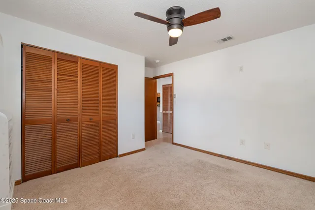a view of an empty room with wooden floor and a fireplace