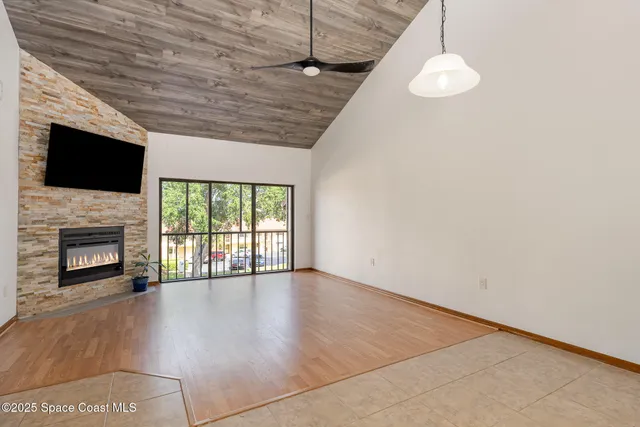 a view of an empty room with a fireplace and a window