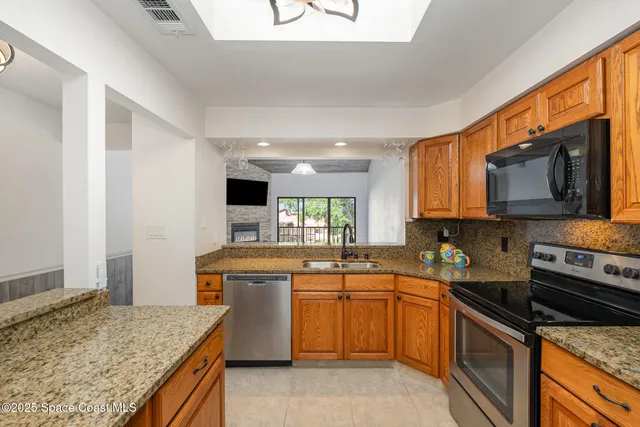 a kitchen with stainless steel appliances granite countertop a sink stove and microwave