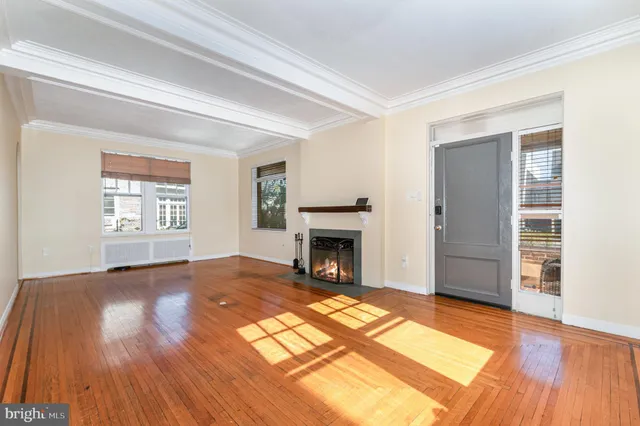 an empty room with fireplace wooden floor and windows