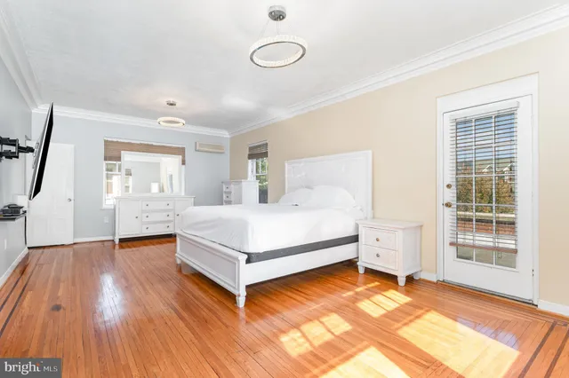a white bed sitting in a room next to a window