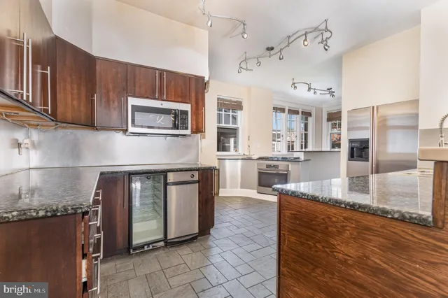 a kitchen with stainless steel appliances granite countertop a stove a sink and a microwave