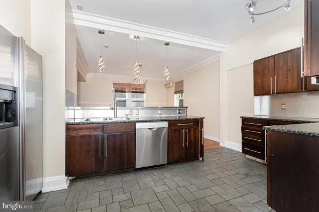 a large kitchen with stainless steel appliances granite countertop a stove and a sink