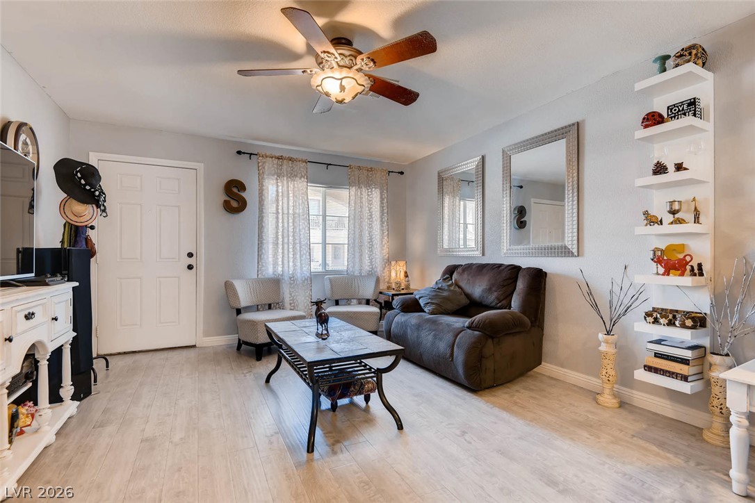 10451 Processor Court Las Vegas, NV 89129 - Photo 7 of 28 A comfortable living space boasts durable laminate flooring and a ceiling fan for year-round comfort.