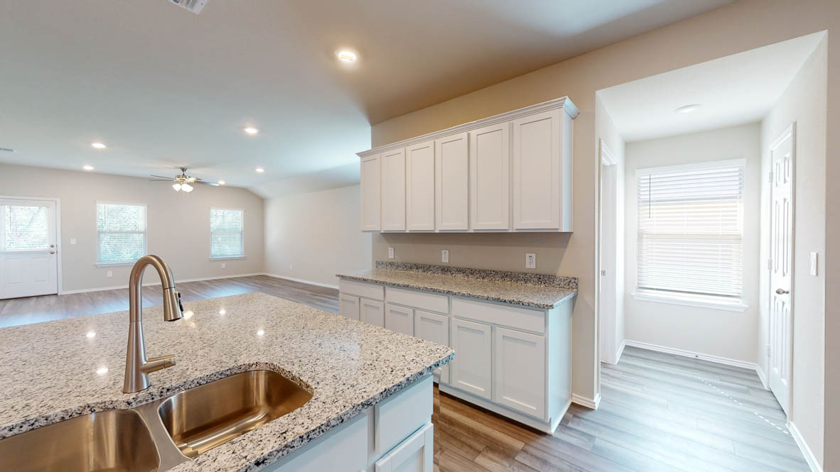 509 Hector Loop Georgetown, TX 78626 - Photo 7 of 31 A well-lit kitchen boasts granite counters and abundant cabinetry, perfect for culinary adventures.
