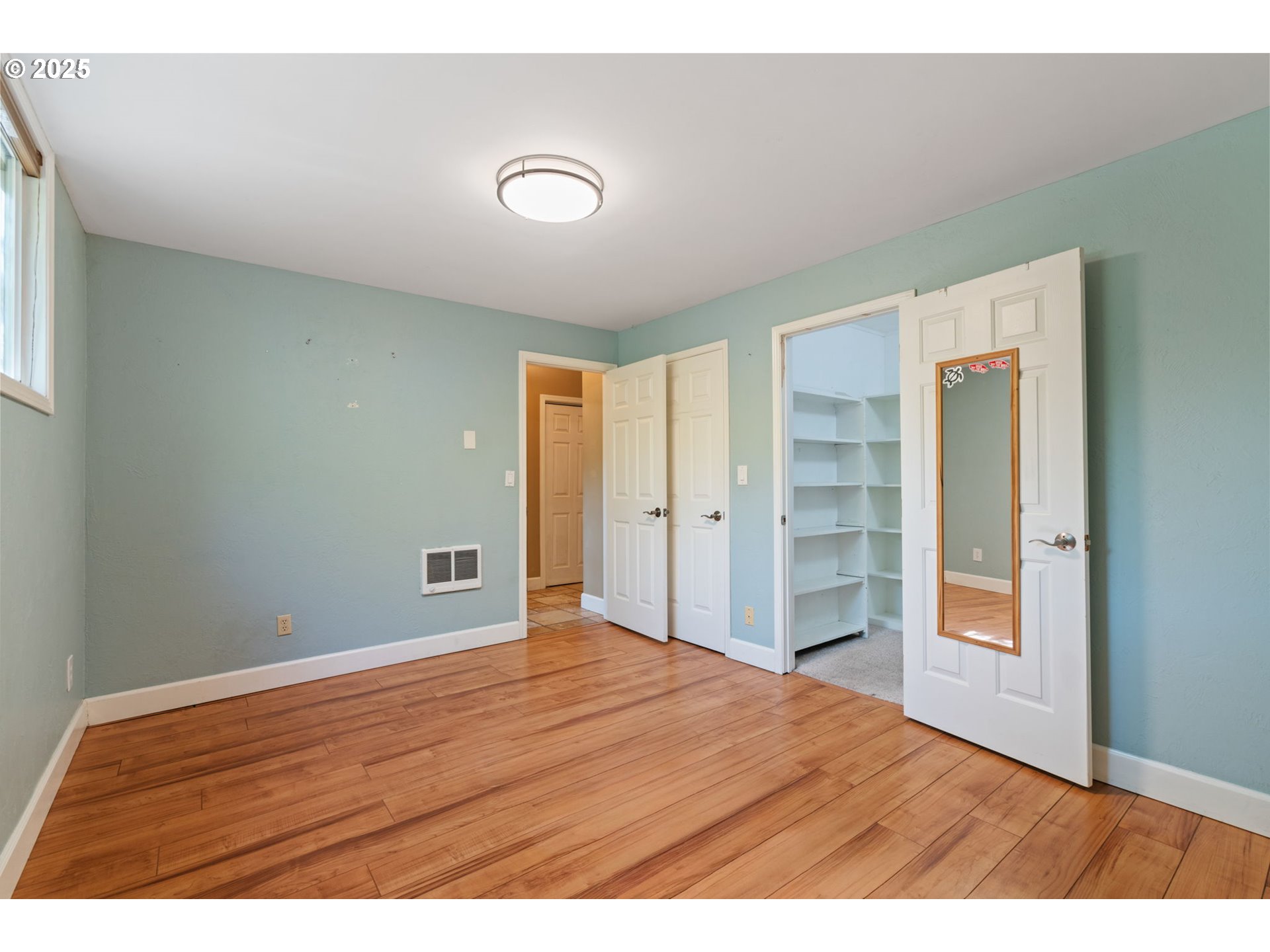 901 Northwest 319th Street Ridgefield, WA 98642 - Photo 24 of 38 a view of an empty room with closet and wooden floor