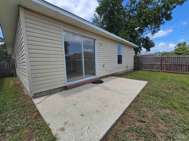 a view of backyard with wooden fence