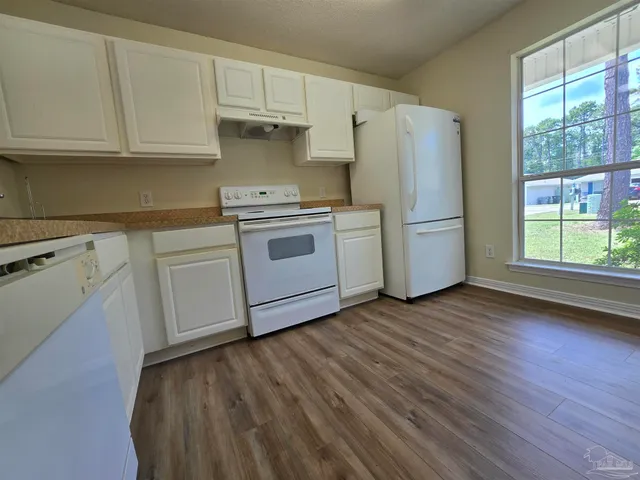 a kitchen with a white cabinets and white appliances
