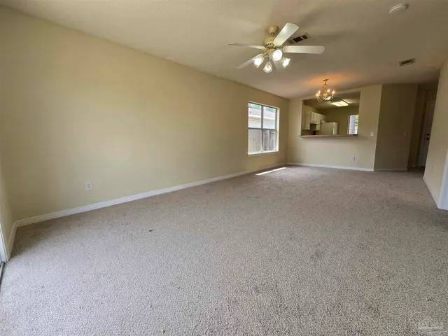 an empty room with a window and a ceiling fan