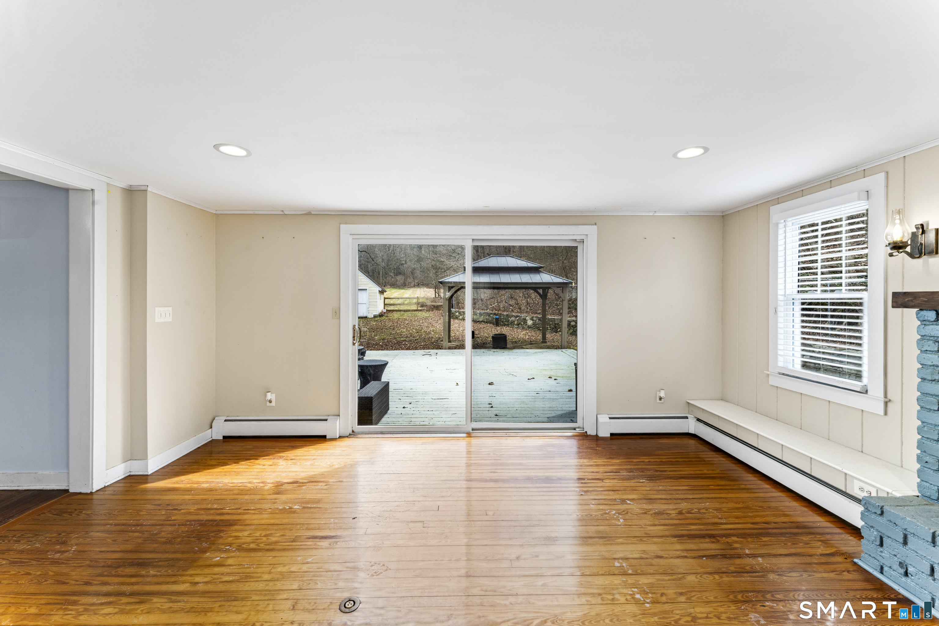 74 Middle Quarter Road Woodbury, CT 06798 - Photo 13 of 40 a view of an empty room with wooden floor and a window