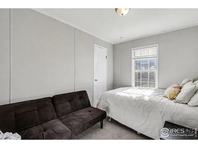 a bedroom with a bed window and couch