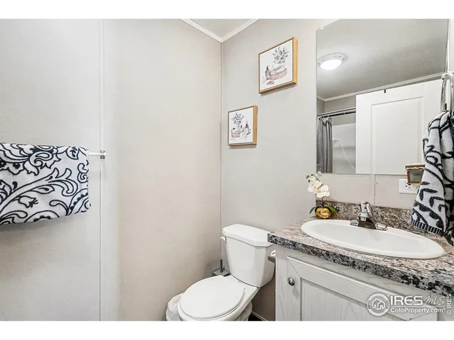 a bathroom with a granite countertop sink mirror vanity and toilet