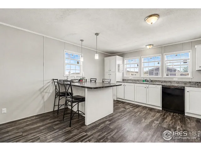 a kitchen with a sink cabinets and wooden floor