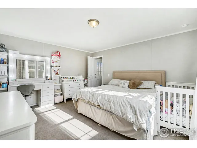 a bedroom with a white bed and white cabinets