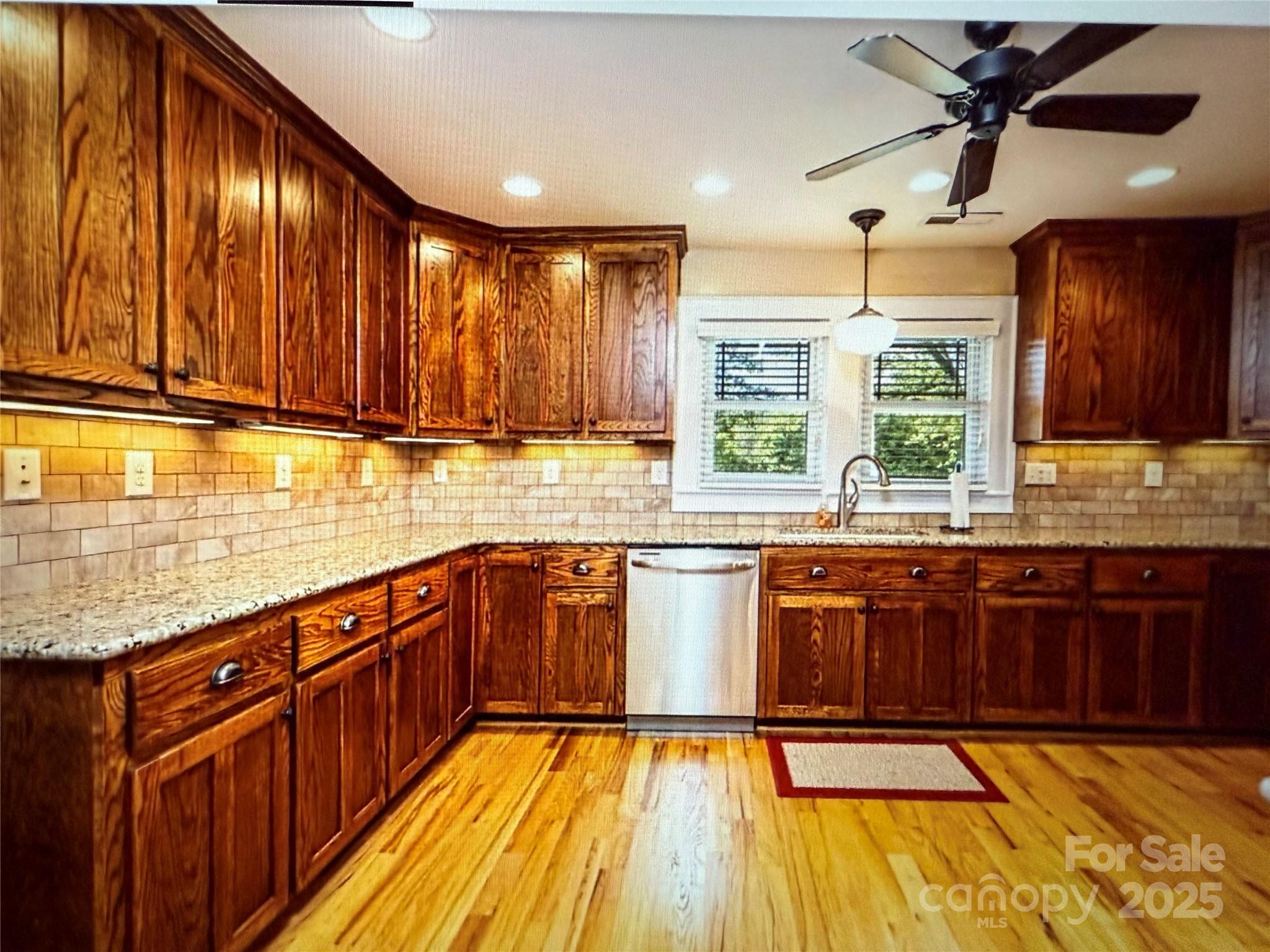 1170 Gold Knob Road Salisbury, NC 28146 - Photo 5 of 34 a kitchen with stainless steel appliances wooden cabinets a stove top oven a sink and dishwasher with wooden floor