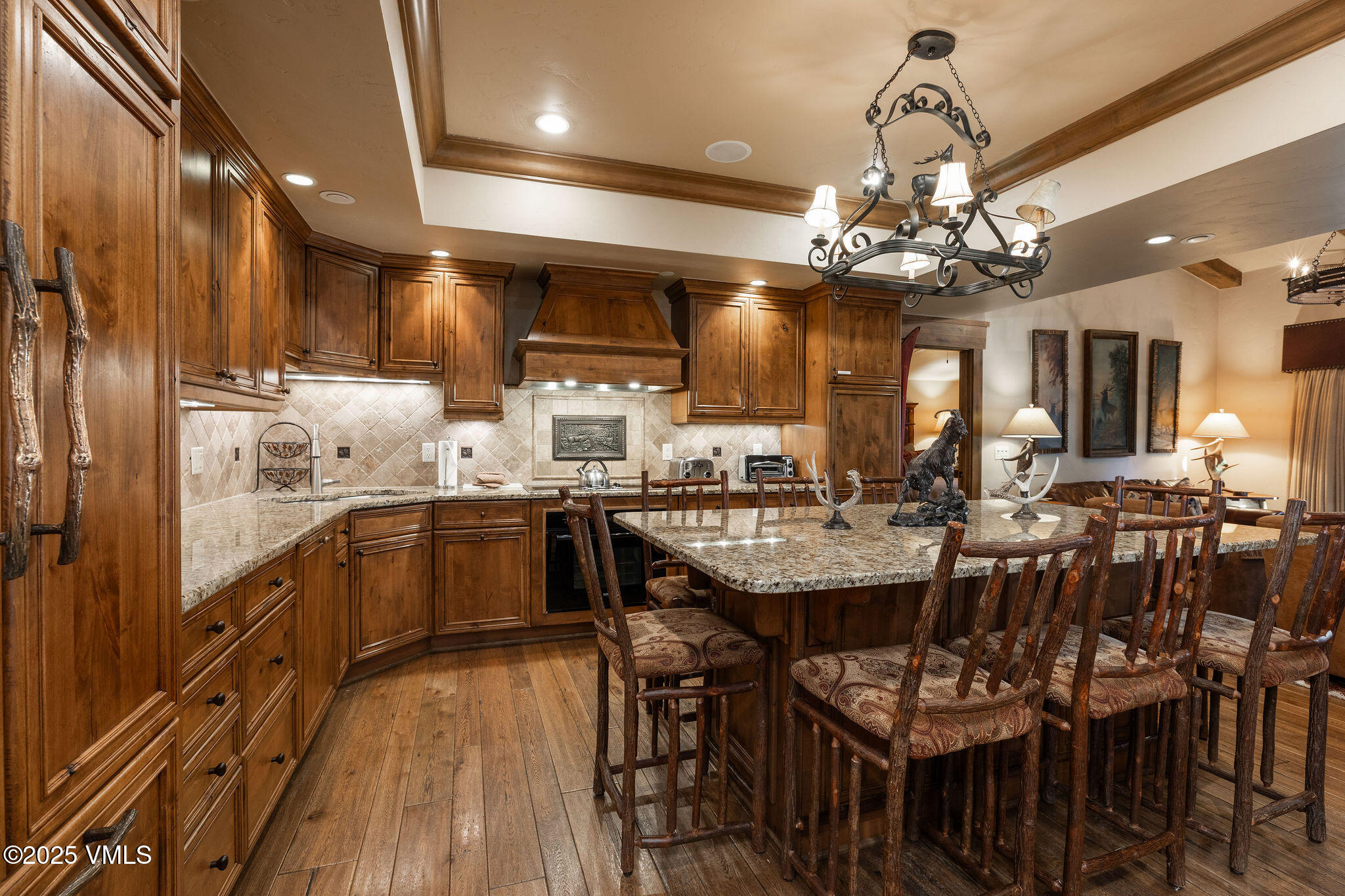 120 Offerson Road, Unit 7410/15 Beaver Creek, CO 81620 - Photo 11 of 15 a kitchen with stainless steel appliances kitchen island granite countertop a table chairs and a wooden floor