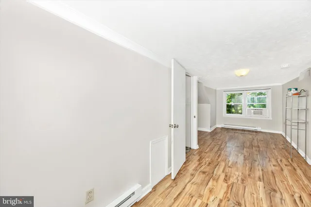 a view of a room with wooden floor and a window