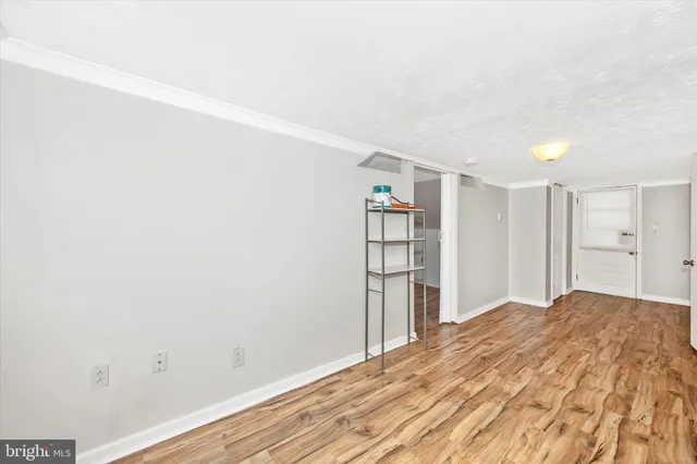 a view of empty room with wooden floor