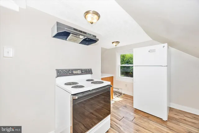 a kitchen with a refrigerator and a stove top oven