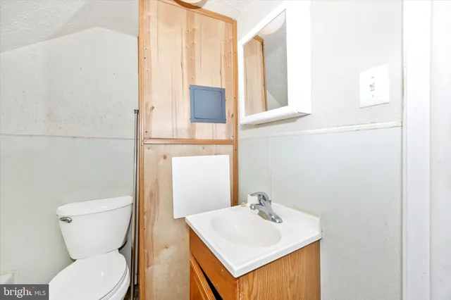 a bathroom with a toilet sink and mirror