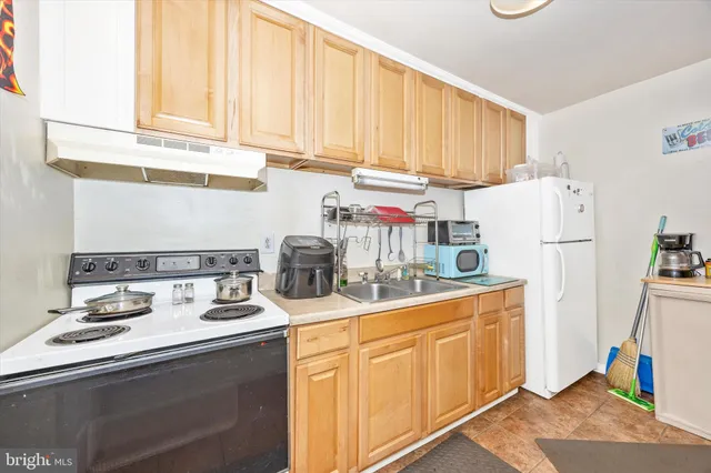 a kitchen with sink a refrigerator and cabinets
