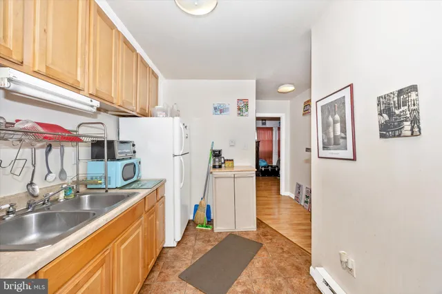 a kitchen with stainless steel appliances granite countertop a refrigerator a stove and a sink with wooden cabinets