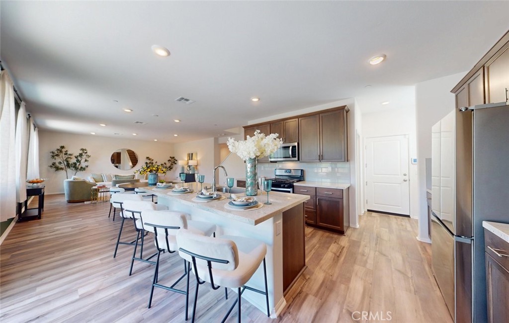 24320 Insignia Drive Menifee, CA 92584 - Photo 23 of 65 a view of a dining room with furniture a chandelier and wooden floor