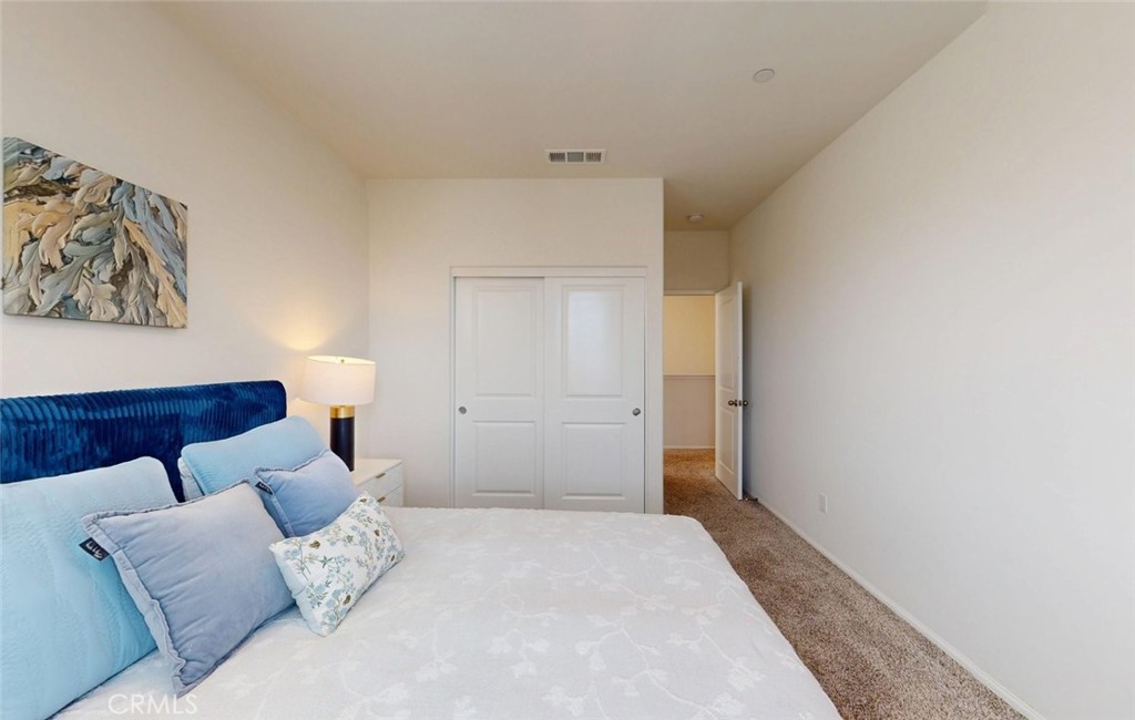 24320 Insignia Drive Menifee, CA 92584 - Photo 30 of 65 a bedroom with a bed and a couch