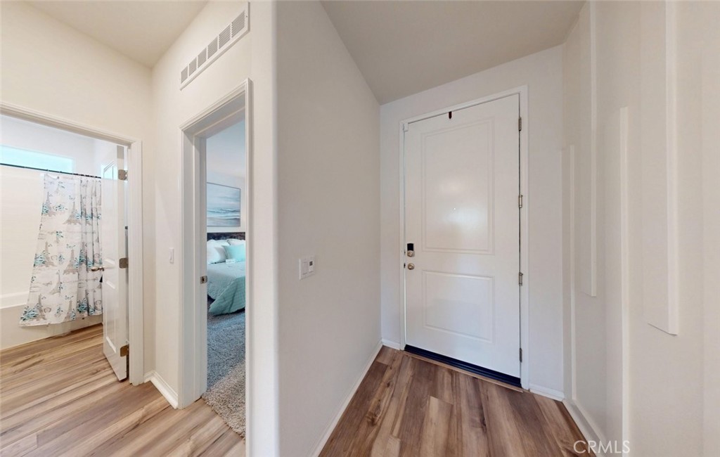 24320 Insignia Drive Menifee, CA 92584 - Photo 3 of 65 a view of a hallway with wooden floor and a bathroom