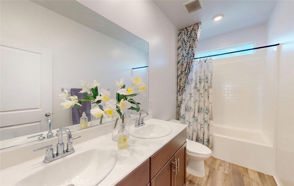 24320 Insignia Drive Menifee, CA 92584 - Photo 40 of 65 a bathroom with a granite countertop sink a toilet and shower