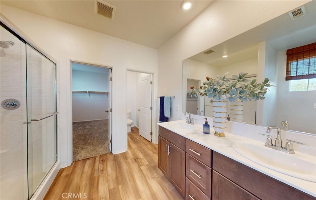 24320 Insignia Drive Menifee, CA 92584 - Photo 46 of 65 a spacious bathroom with a double vanity sink a mirror and a shower