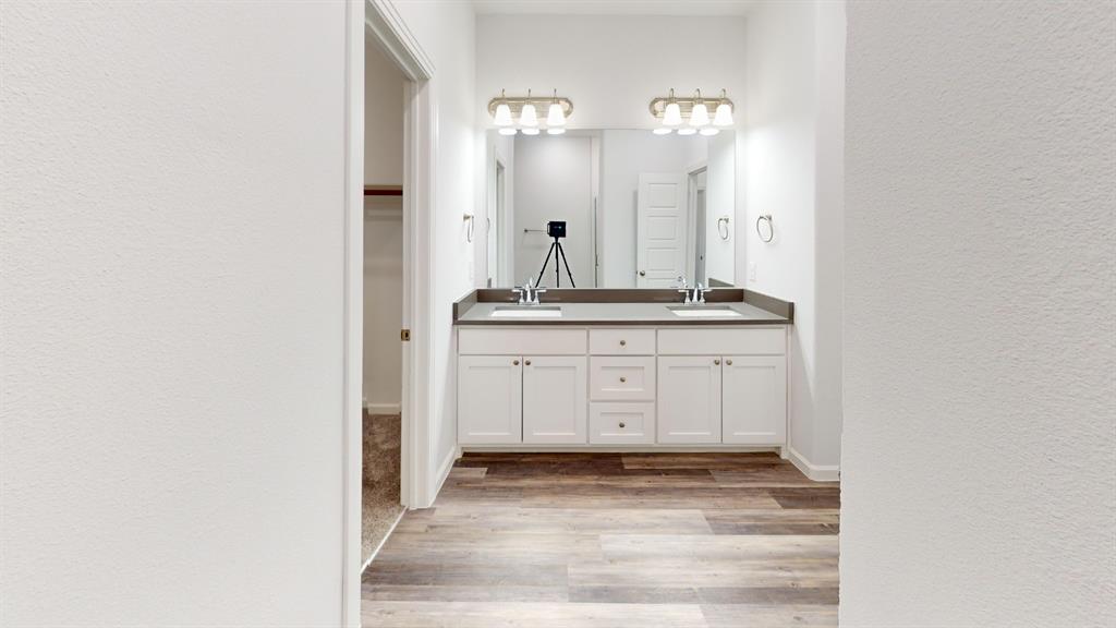 336 Buck Ridge Drive Frisco, TX 75068 - Photo 20 of 23 Double vanity with white cabinetry and integrated sinks, complemented by a gray countertop and brushed nickel hardware