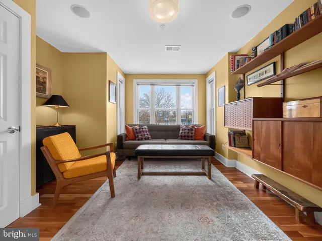 a living room with furniture a rug and a window