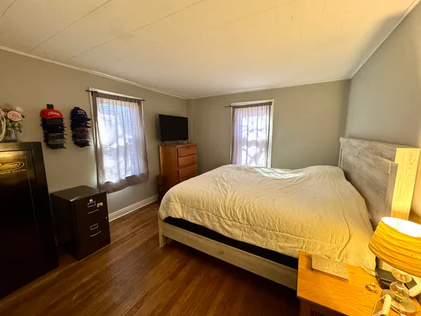 a bedroom with a bed and dresser with window