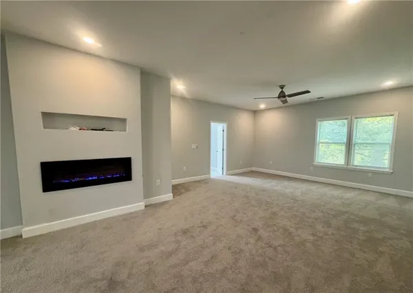 an empty room with windows and fireplace