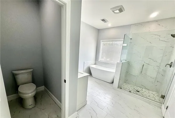 a bathroom with a toilet and a shower