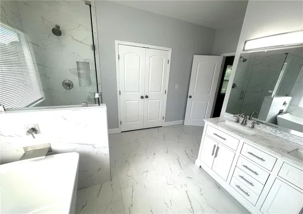 a en suite bathroom with a granite countertop sink and a mirror