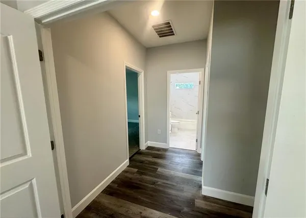 a view of a hallway with wooden floor and closet