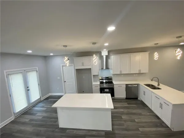 a large white kitchen with wooden floor