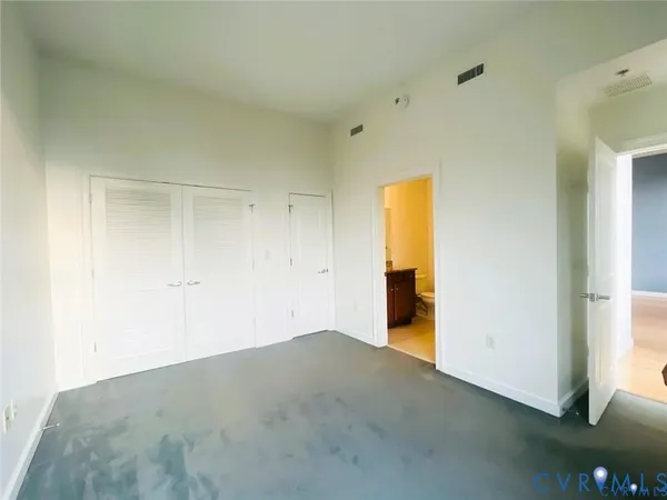 a view of an empty room with glass door and wooden floor