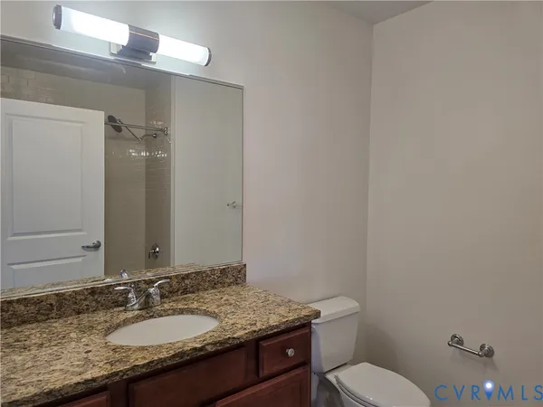 a bathroom with a granite countertop sink toilet and shower