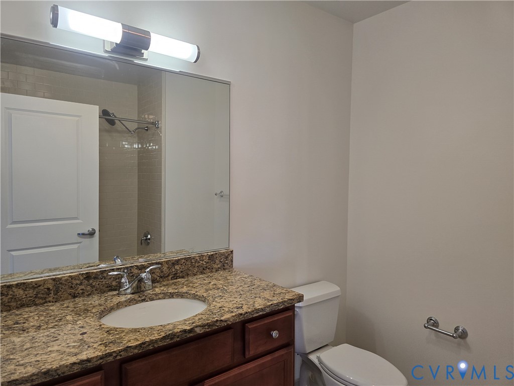230 North 6th Street, Unit U318 Richmond, VA 23219 - Photo 14 of 24 a bathroom with a granite countertop sink a toilet and mirror