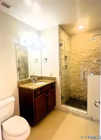 a bathroom with a granite countertop sink a toilet and a mirror