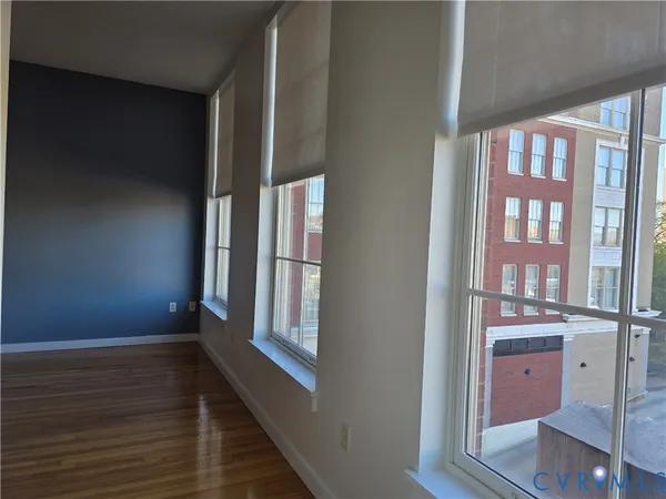 a view of empty room with wooden floor