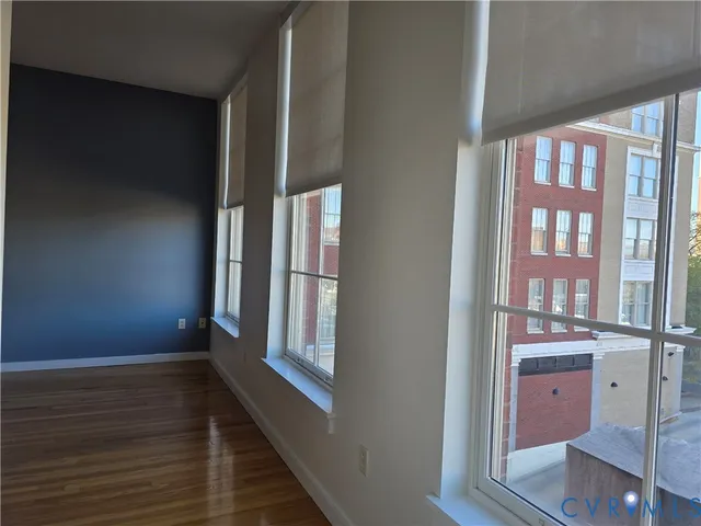 a view of empty room with wooden floor