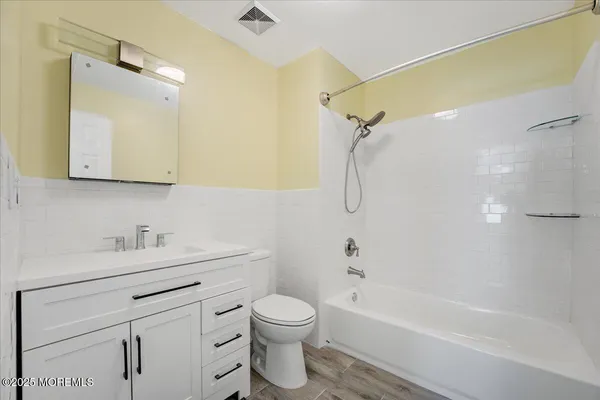 a bathroom with a bathtub shower sink vanity and toilet