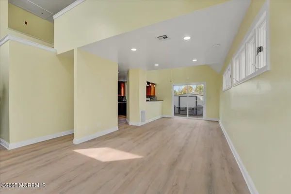 a view of empty room with wooden floor