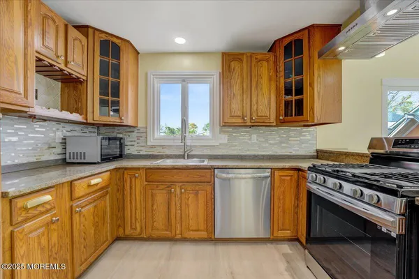 a kitchen with stainless steel appliances granite countertop a stove and a sink