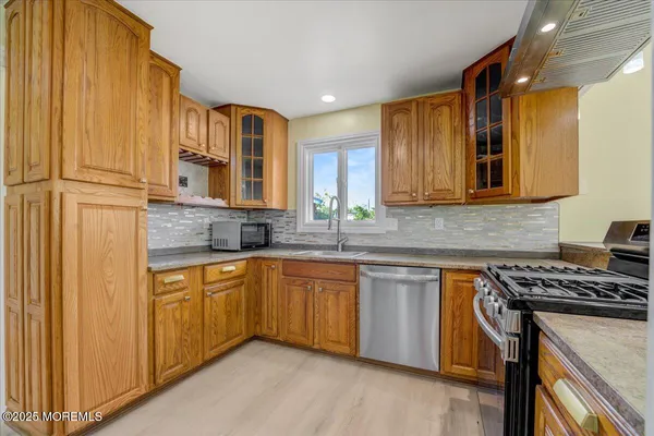 a kitchen with stainless steel appliances granite countertop a stove a sink and a microwave