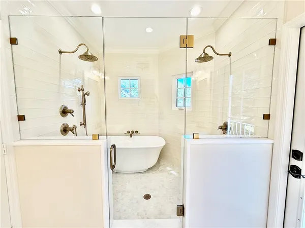 a bathroom with a sink vanity granite tub shower and a mirror
